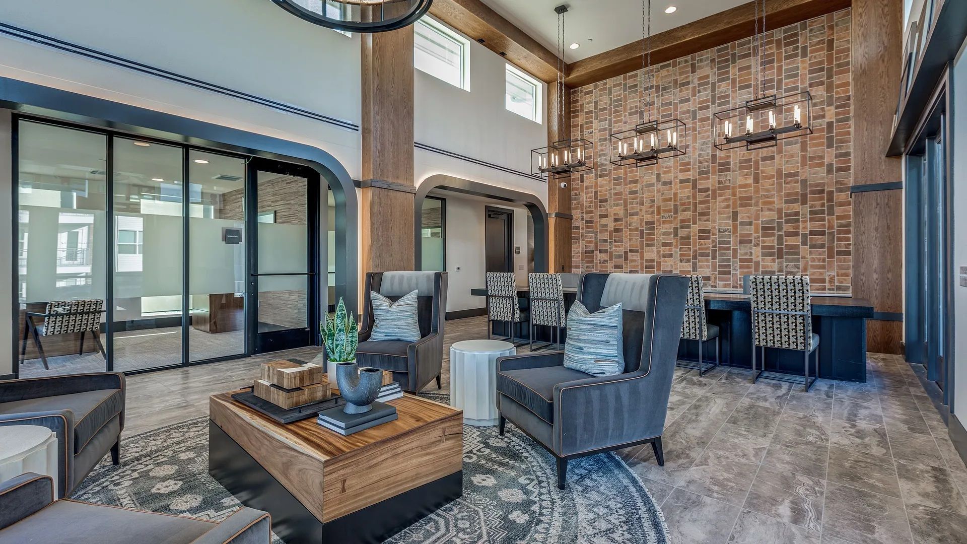 A modern interior with a seating area, a coffee table, and a brick wall.