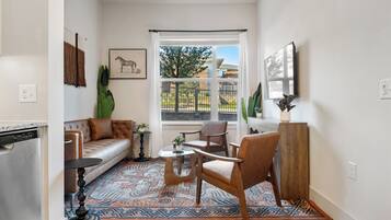 A modern living room with a sofa, chairs, a coffee table, and a patterned rug.