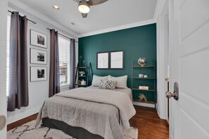 A bedroom with a bed, a window with blinds, a ceiling fan, and a door. - 3bed/3bth Just Minutes from Downtown (Nashville)