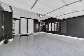 A spacious, modern room with a large mirror, a ceiling-mounted projector, and a black and white color scheme. - 3bed/3bth Just Minutes from Downtown (Nashville)