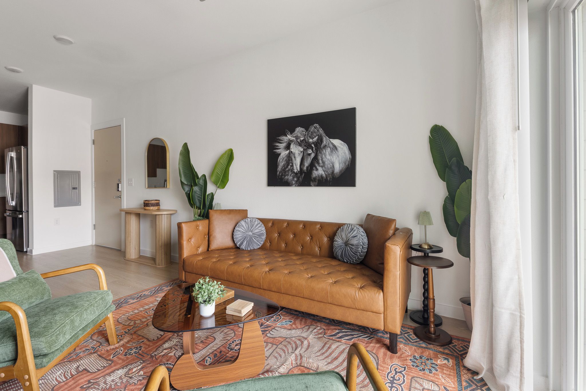 A living room with a leather sofa, a coffee table, and a patterned rug.