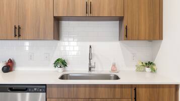 A kitchen with wooden cabinets, a stainless steel sink, and a dishwasher.