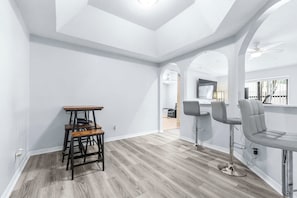 Ein modernes Interieur mit Barbereich, Holzboden und weißen Wänden.