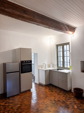 A kitchen with a refrigerator, oven, and sink. - Maison Belon · Entire village house, 4 apartments, in the heart of Uzès (Uzès)