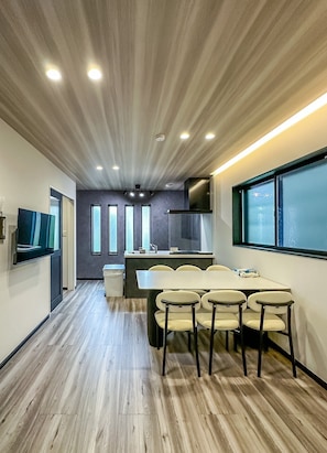 Una cocina moderna con comedor, suelo de madera y un ventanal grande.