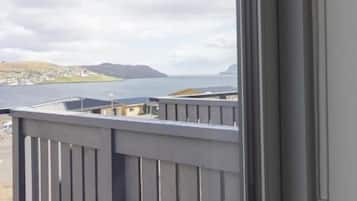 A balcony with a view of a body of water and distant land.