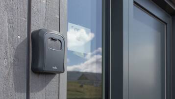 A door with a glass panel and a doorbell button on the wall.