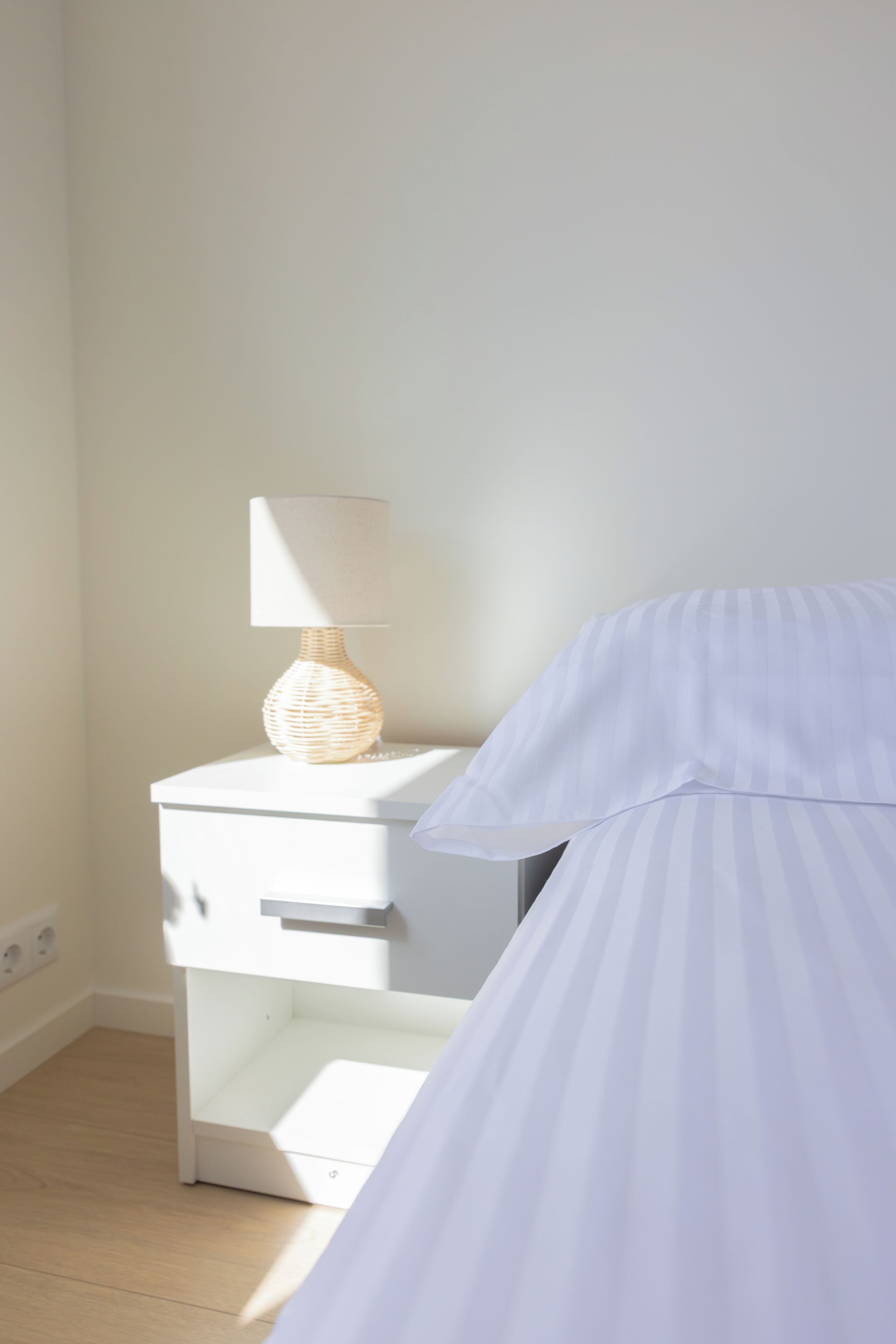 Ein Schlafzimmer mit einem Bett, einem Nachttisch mit Lampe und einem kleinen Tisch.