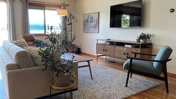 A modern living room with a sofa, a coffee table, a TV, and a cabinet.