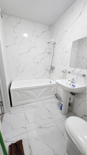 A bathroom with a bathtub, a sink, and a toilet. - Standart 3 Bedroom Flat for Groups & big Families (Tashkent)