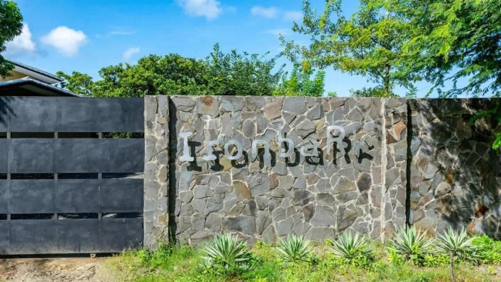 A stone wall with the name 'Ironbark' and a metal gate.