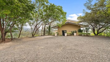 A building with a gravel driveway and trees.