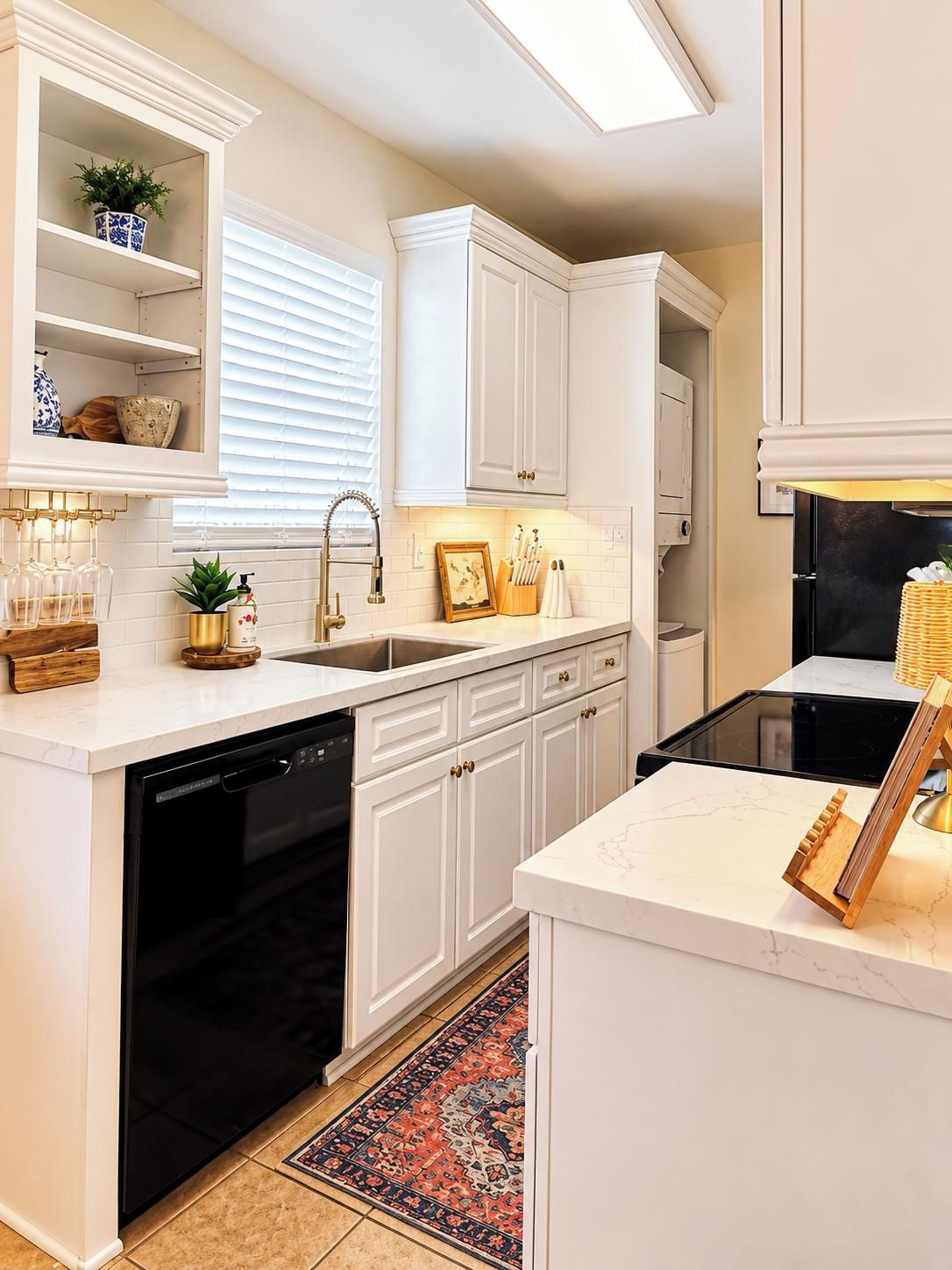 A modern kitchen with white cabinetry, a black dishwasher, and a black stove.