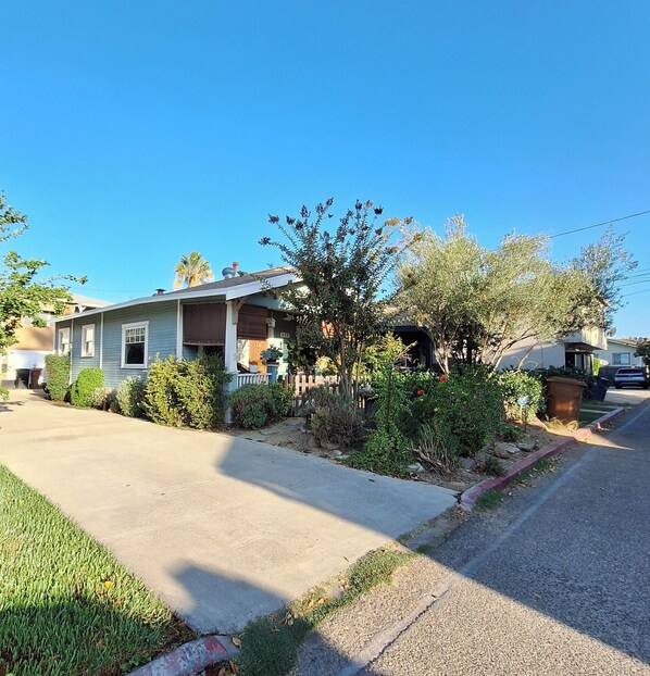 A residential street with houses, a clear sky, and a well-maintained lawn. - Charming 2-Bdrm Historic Bungalow~ Hummingbird Garden & HotTub in DT Fullerton! (Fullerton)