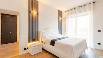 Ein modernes Schlafzimmer mit einem Bett, Nachttischen, einem Kleiderschrank und einem Fenster mit Vorhängen.