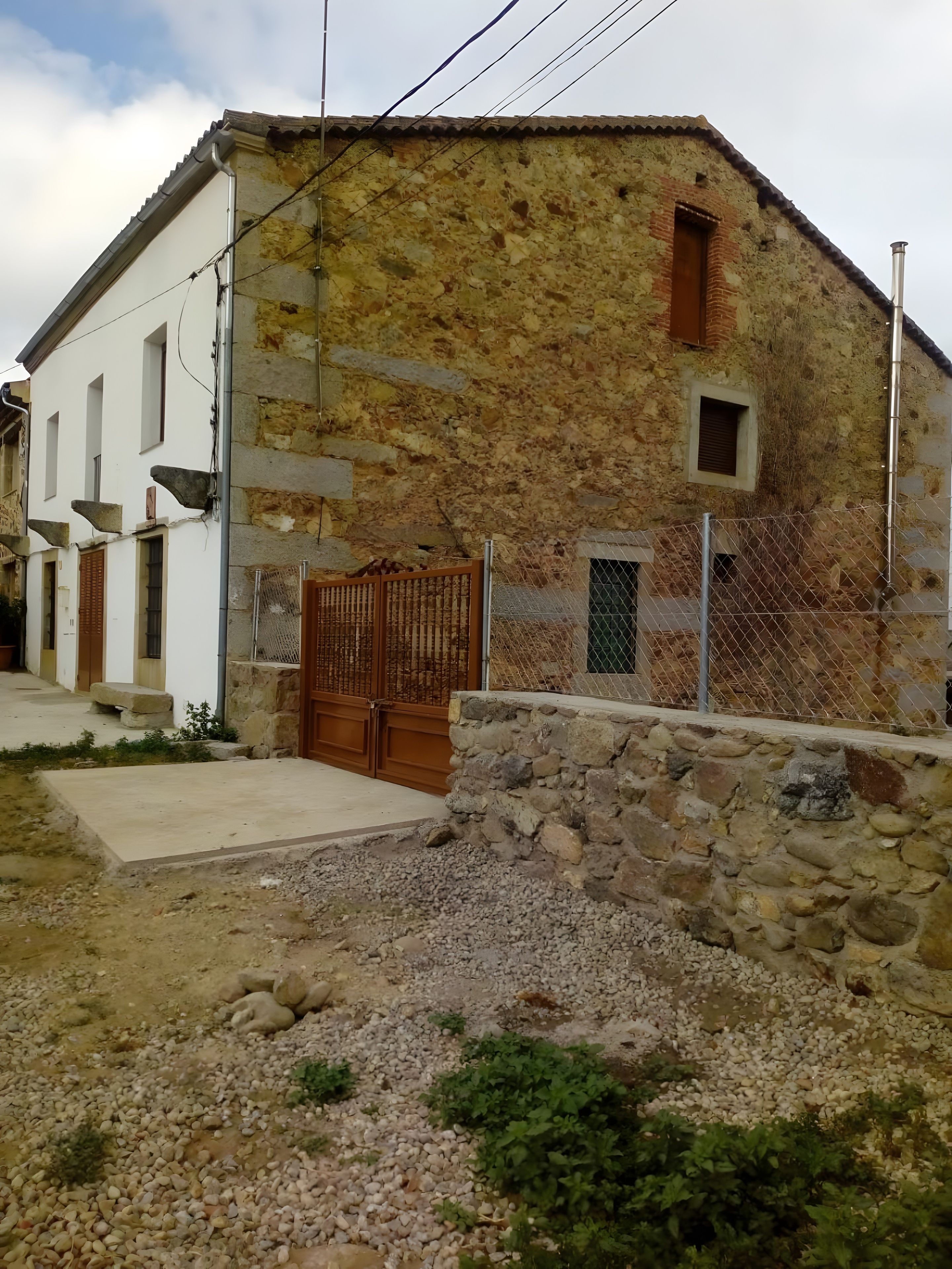 A rustic stone building with a wooden door and a small window.