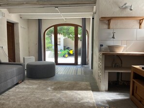 A living room with a sofa, ottoman, and a view of the outside. - New traditional-style villa just a stone's throw from a beautiful cove (Jávea)