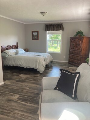 A bedroom with a double bed, a dresser, a window with a view of greenery, and a ceiling light fixture. - Country life,come and relax! (Crossville)