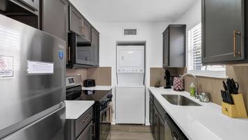 A modern kitchen with stainless steel appliances, a built-in oven, and a refrigerator.
