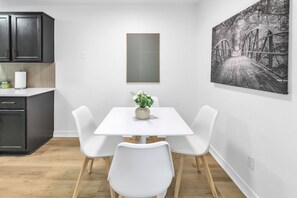 Una cocina moderna con armarios oscuros, una encimera blanca y una pequeña planta.
