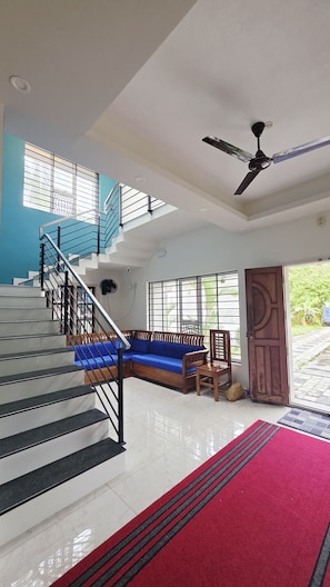 Un intérieur moderne avec un escalier, un canapé bleu et un tapis rouge.