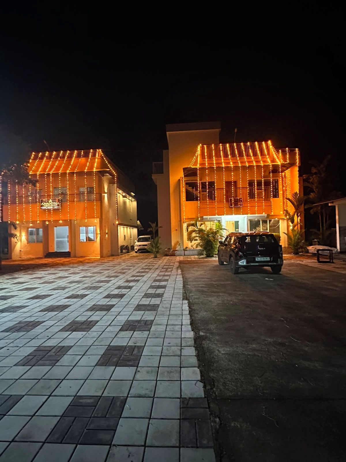 A building with a tiled entrance area and a vehicle parked in front.