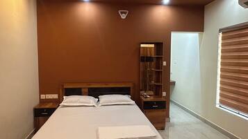 A bedroom with a bed, nightstands, a ceiling fan, and a window with blinds.