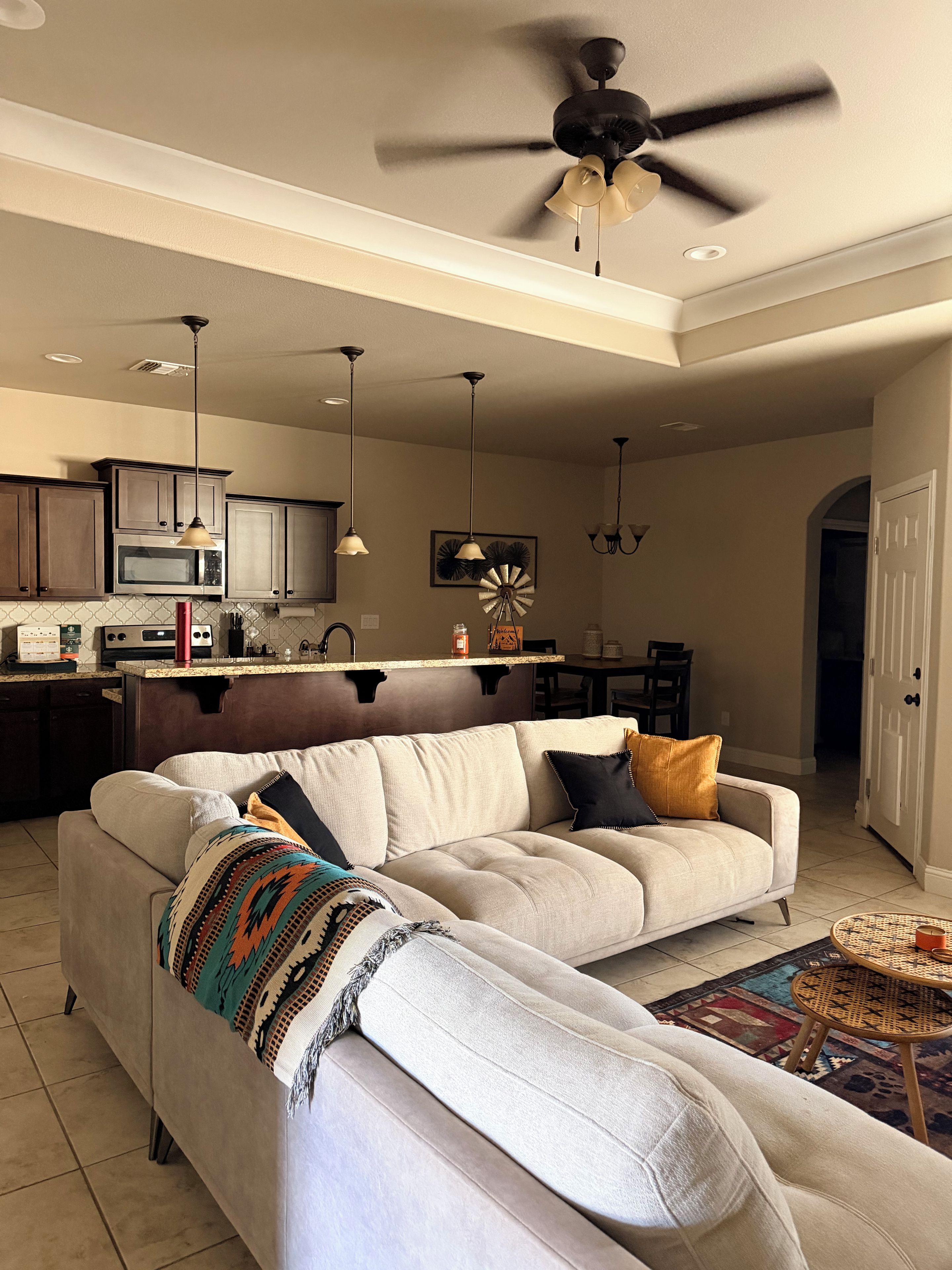Una sala de estar moderna con un sofá modular, un comedor y una cocina.