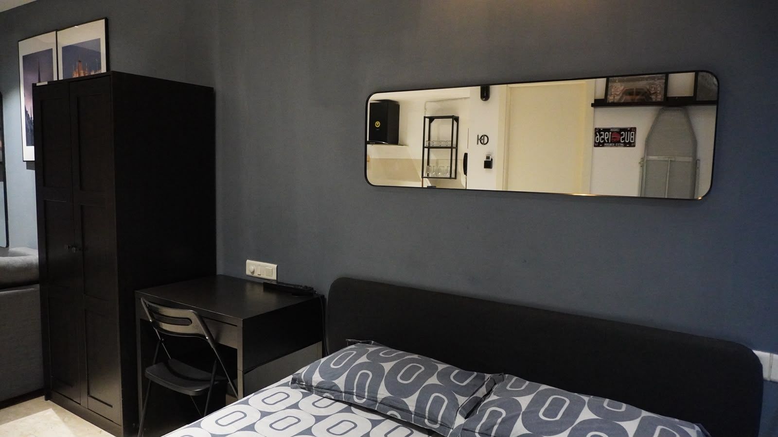 A room with a bed, a desk, and a wardrobe.