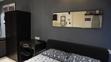 A room with a bed, a desk, and a wardrobe.