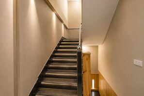 Uma escadaria moderna com corrimão de madeira e guarda-corpo de metal.