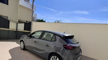 Une berline grise était garée dans une allée, sous un ciel dégagé.