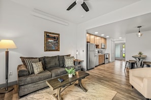 A modern living room with a sofa, coffee table, and a painting on the wall. - Riverfront Condo Only 10 Minutes to the Resort! Pet Friendly. (Steamboat Springs)