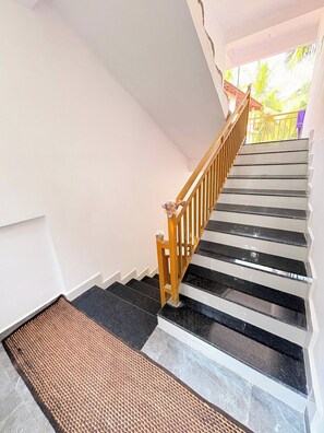 Eine Treppe mit Holzwandhandlauf, der zu einer oberen Etage führt.