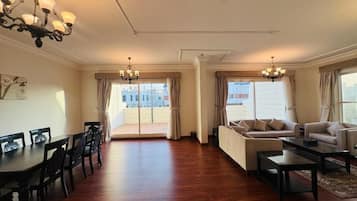 A spacious living room with a dining area, two sofas, a coffee table, and a chandelier.