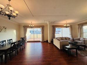 A spacious living room with a dining area, two sofas, a coffee table, and a chandelier. - Al Jawhara Suite Serviced Apartments 2 (Taif)