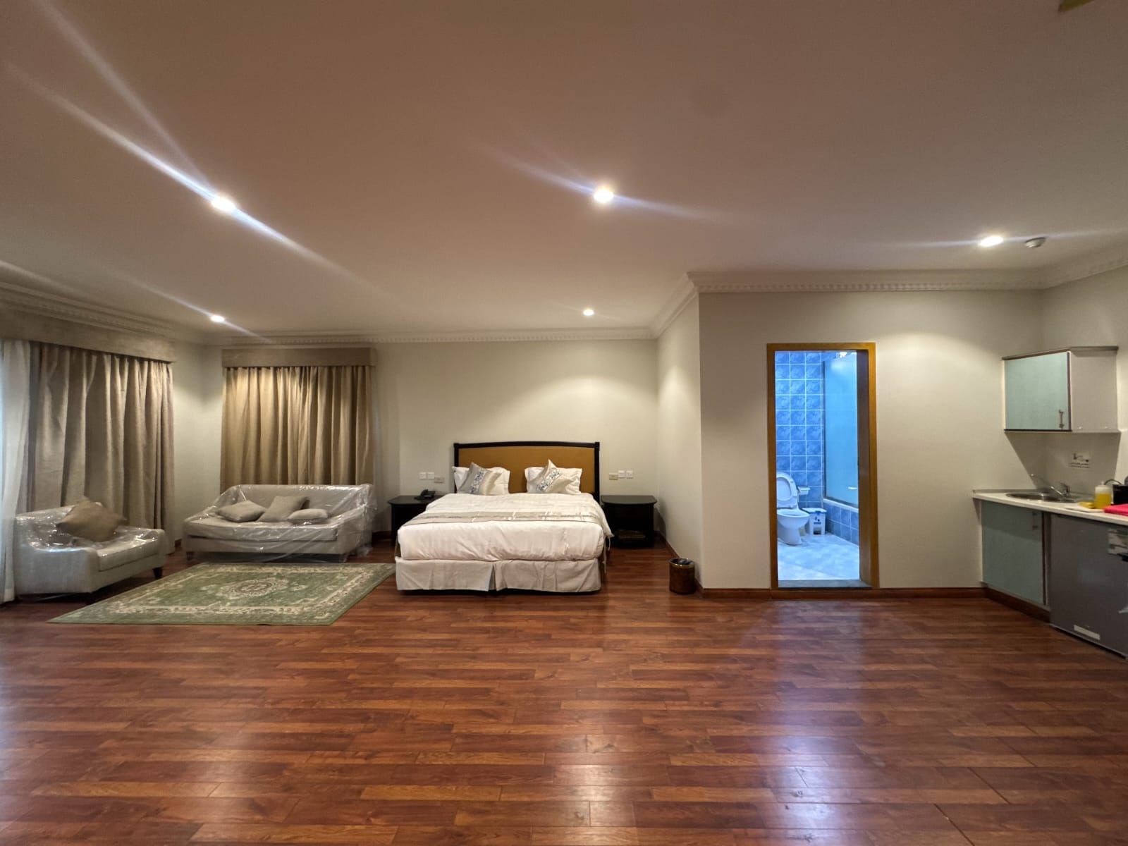 Un dormitorio amplio con una cama grande, un área de descanso y vistas al exterior.