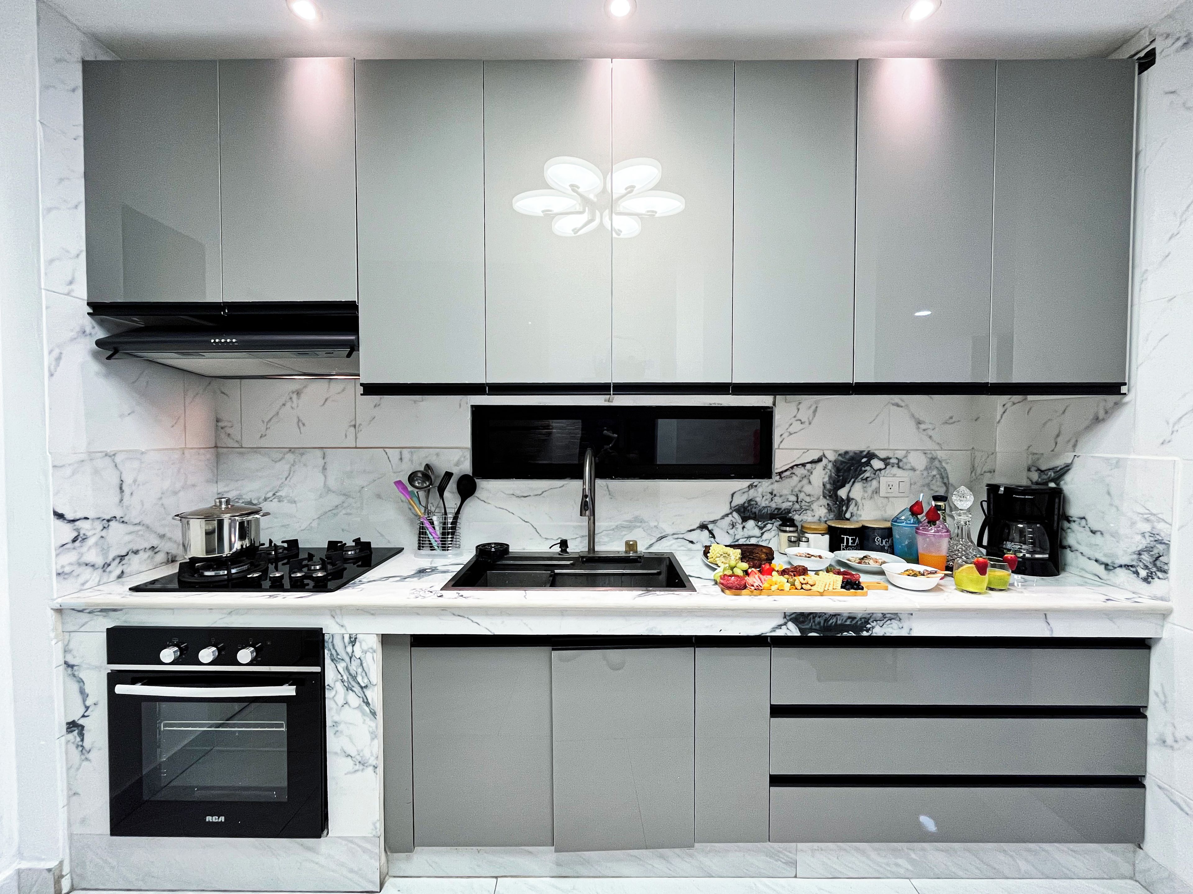 A modern kitchen with a built-in oven, a gas stove, and a microwave.