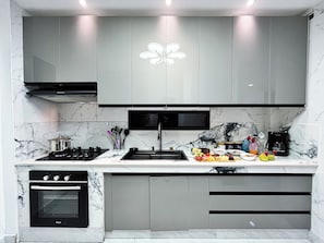 A modern kitchen with a built-in oven, a gas stove, and a microwave. - NAPOLI 14.8 (La Aurora)