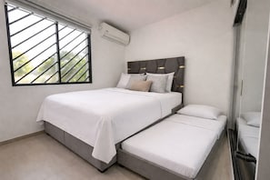 A bedroom with a bed, a smaller bed, a window with blinds, and an air conditioning unit. - NAPOLI 14.8 (La Aurora)
