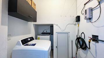 A laundry room with a washing machine, a dryer, and a door.