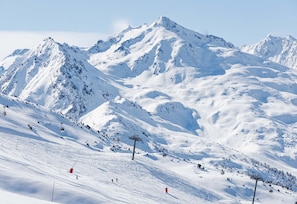 Ein mit Schnee bedeckter Berg mit Skiliften und Skifahrern.