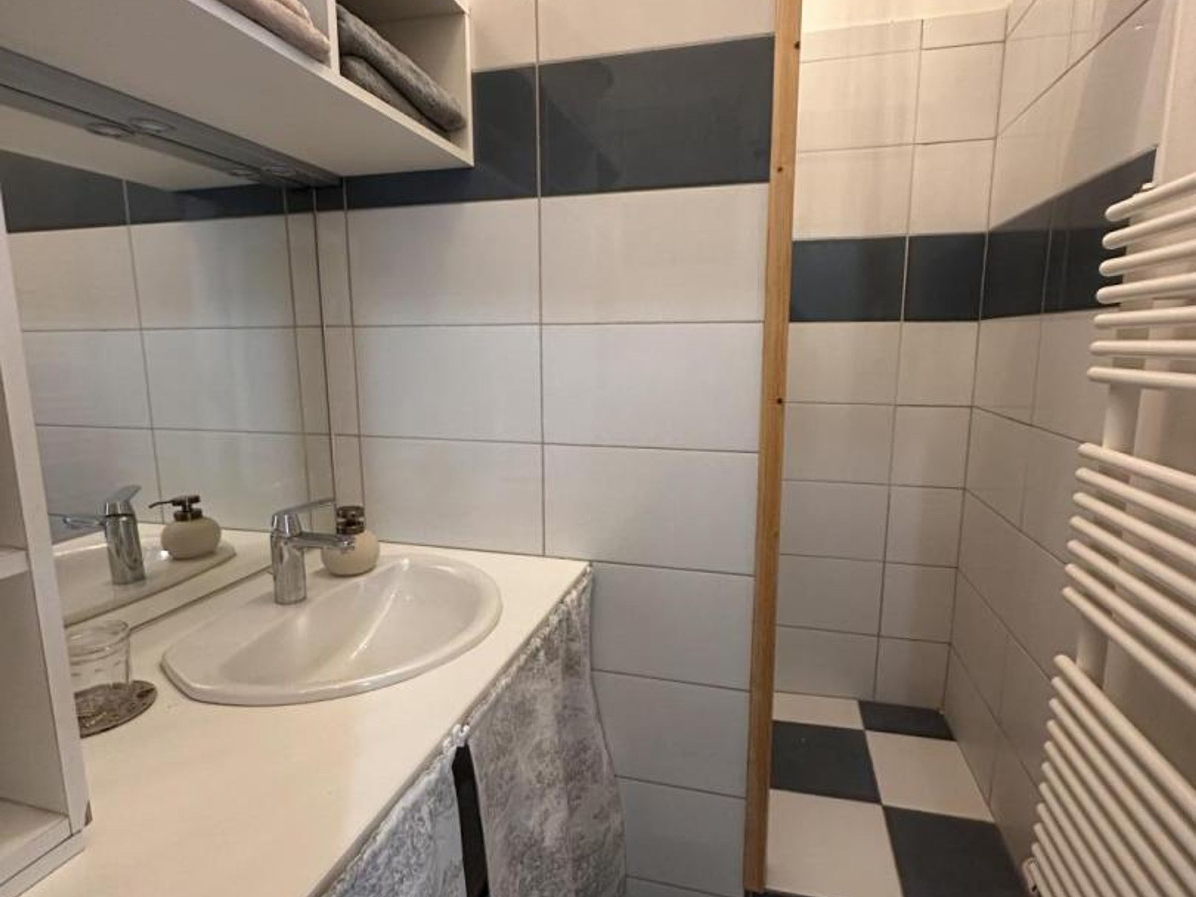 Une salle de bain équipée d’un lavabo, d’un miroir et d’un porte-serviettes.