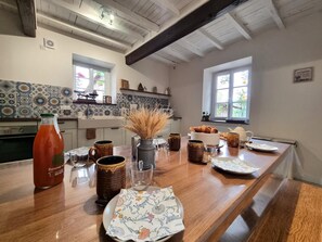 A kitchen with a long wooden countertop, various kitchenware, and a bottle of sauce. - Spacious house, pets allowed, panoramic view - 12 guests (Saint-Alban-les-Eaux)