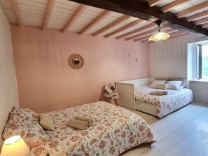 Ein Schlafzimmer mit zwei Betten, einem runden Spiegel und einem Fenster.