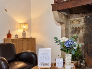A room with a leather sofa, a lamp, a fireplace, and a welcome sign. - Spacious house, pets allowed, panoramic view - 12 guests (Saint-Alban-les-Eaux)