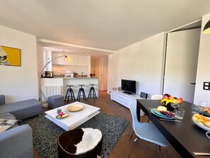 A modern apartment with a living room, dining area, kitchen, and a small bar area. - Cozy apartment - 5 guests (Vars)