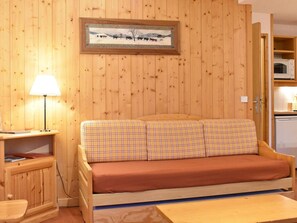 A wooden cabin interior with a sofa, a lamp, and a painting on the wall. - Cozy apartment mountain view - 5 guests (Méribel)