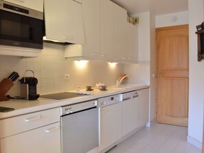 A modern kitchen with white cabinetry, a built-in microwave, and a dishwasher. - Ski-in apartment, valley view - 4 guests (Méribel)