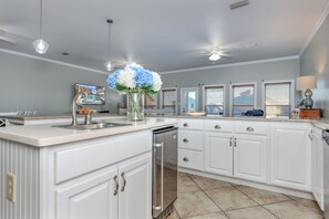 A kitchen with white cabinetry, a central island, a dishwasher, and a ceiling fan. - Flip Oasis Lockout · Coastal Comfort: Hot Tub, Foosball & Arcade (Gulf Shores)